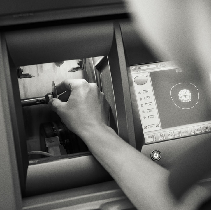 Hand justiert eine Maschine mit Display; schwarz-weiß Foto.